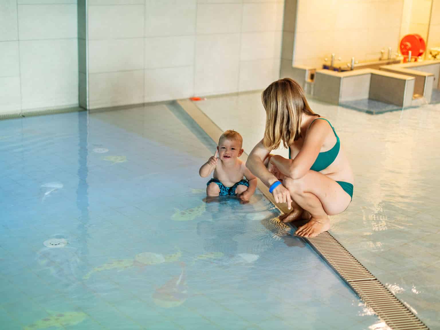 Mutter und Kind bei der Fischprojektion in der Säntispark Kinderbadewelt